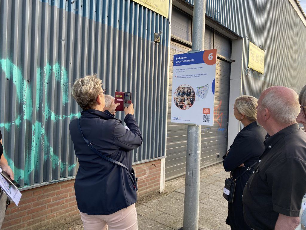 Een bezoeker maakt een foto van het bord langs de wandelroute